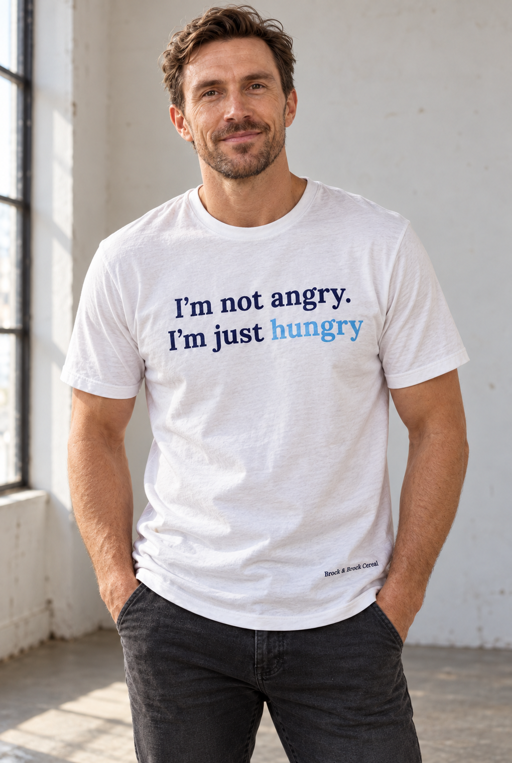Model wearing a white I’m not angry. I’m just hungry T-shirt with Brock & Brock Cereal branding near the lower-right hem